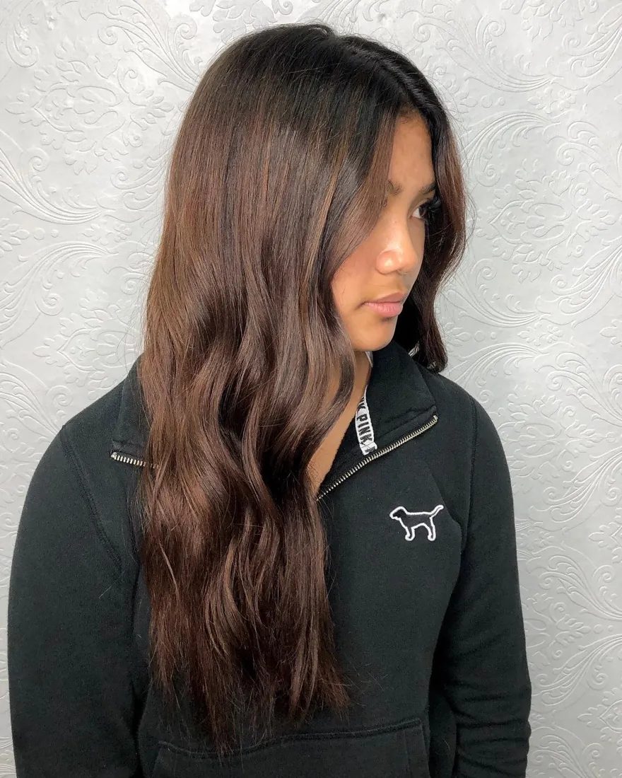 Long brunette hair with extension lengths blended seamlessly through the ends, by Hello Beauty Lounge in Red Deer